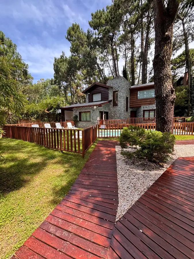 Cabaña de piedra y madera con pileta entre los pinos