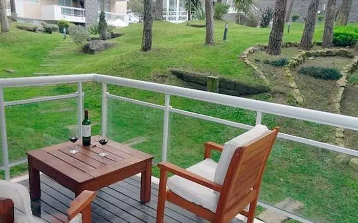 Balcón con mesa y vista al jardín